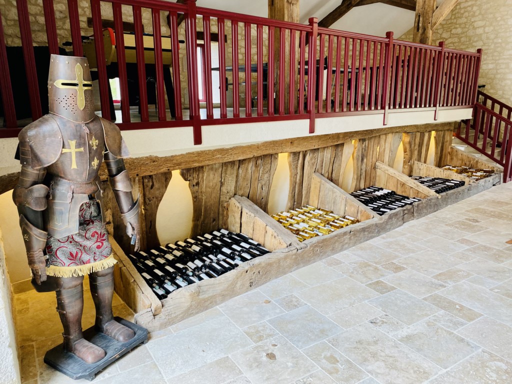 bouteilles de vin exposées gardées par un chevalier en armure medievale